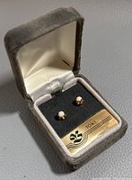 Pair of 10K yellow gold stud earrings with opal stones in a grey velvet presentation box with a satin interior and a label indicating '10 kt.'