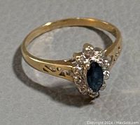 Front view of ring showing marquise sapphire center and diamond halo