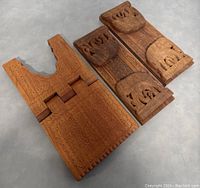 Close up photo of the two wooden items folded flat showing intricate carvings and sliding mechanism