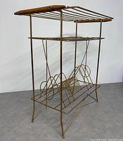 Angled side view showing brass wire frame and wooden handles