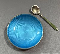 Top view of the small dish showing the blue guilloche enamel and spoon beside it.