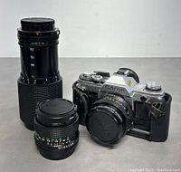 Canon AT-1 body with two lenses attached and standing