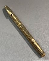 Full pen showing the gold-filled diamond pattern barrel and cap with clip.