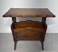 Front view of the vintage wooden magazine rack table showing scalloped tabletop and magazine holder front panel.