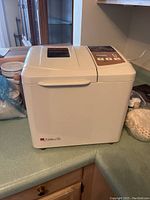 Front view of white KitchenAid bread maker placed on kitchen counter.