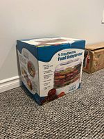 Boxed 5-tray electric food dehydrator showing product image and branding.