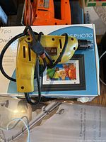 Yellow electric hand drill with power cord, showing details including labeling and ventilation slots.