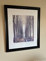 Image of a framed picture showing a winter scene with a path lined by leafless trees.