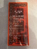 Photo of the 40 piece tap and die set in an orange plastic case with clear lid displaying taps, dies and tools inside