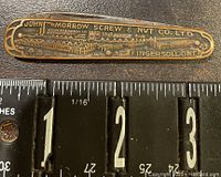 Front of John Morrow Screw & Nut Co. Ltd. pocket tool showing embossed company name and industrial design illustrations.
