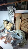Lot overview showing various architectural corbels, wooden shutters, and decorative molding pieces arranged together