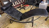 Side view of black leather lounger on chrome curved frame