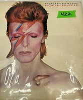 Front cover of David Bowie's Aladdin Sane gatefold LP showing iconic lightning bolt makeup photo on white background.