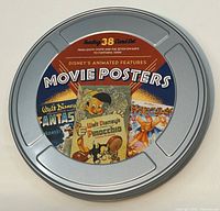 Closed round silver metal tin resembling a film reel with label showing several classic Disney animated movie posters like Fantasia, Pinocchio, and Hercules.