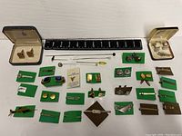 Full assortment layout of cuff links, tie bars, and pins with ruler for size reference