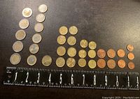 Top-down view showing all coins laid out in rows with ruler at bottom, displaying the 31 total coins arranged by denomination and size.