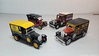 Four Lesney Models of Yesteryear vintage vehicle models display with detailed advertising decals.