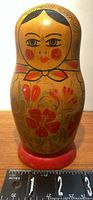 Large wooden nesting doll shown against ruler showing height approx 6.5 inches