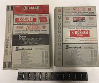 Two city directories open flat showing advertising pages on cover with various local businesses.