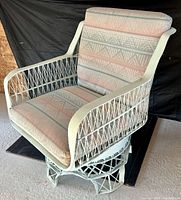 Front view showing the wide seat, cushion, and woven white spun fiberglass frame with the chair base visible.