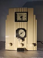 Front view of vintage cream-colored Thomas Art Deco style tabletop radio showing clock with Roman numerals, analog dial tuner, control knobs, and Collector's Edition plaque.