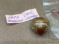 Front view of ring showing red goldstone and handwritten note '1972 14K Munich Olympics'