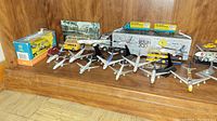 Wide view of shelf with all die-cast planes, boxed VW Combi, promo truck, bus and car