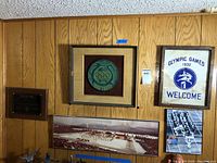 All five framed items displayed together on wood-paneled wall