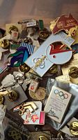 Pile of various Olympic and sports pin badges