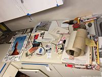 Overview of table with assorted Olympic-related ephemera, including papers, tickets, signatures, and posters.