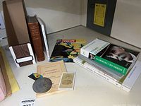 Overview of the lot with books, medal, photograph and magazine spread out on table
