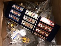 Overview of blue velvet board with Seoul 1988 sport pins and surrounding ziplock bags of assorted pins