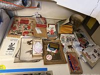 Assorted sports printed ephemera arranged on tabletop, including magazines, booklets, programs, typed sheets, postcards booklet, and loose photographs.