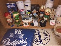 Shelf view showing bobbleheads, cups and assorted memorabilia