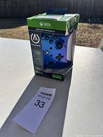 Boxed new PowerA Enhanced Wired Xbox controller blue edition for Xbox One and Windows 10, displayed on table outdoors with original packaging showing.