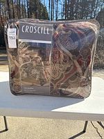Packaged Croscill Bradney Queen comforter set including comforter, two shams, and bedskirt with packaging label visible.