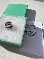 Silver 925 ring on white foam inside a green box, showing the entire ring and packaging setup.