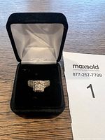 Full view of the silver ring in black velvet ring box with satin lining