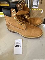 Pair of wheat color Timberland men's boots in size 9.5, showing profile and padded collar.