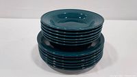Stack of 6 dessert plates and 6 dinner plates showing glossy teal green-blue color and ringed design.