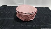 Closed pink quilted fabric cover containing the set of bowls for storage or transport.