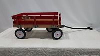 Side view of vintage Radio Flyer Rodeo wagon showing entire wooden body, metal wheels, and pull handle.