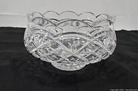Full view of the Waterford footed crystal bowl on a black surface, showing scalloped edges and deep cut crystal pattern.