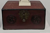 Front view of antique Korean chest showing brass lock and circular motifs.
