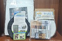 Quilted vinyl storage cases, rug plate holders, furniture repair markers, and pop-up trash can displayed on a wooden surface.