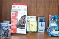 Full lot showing surge protector, lamp dimmers, outlet converter, timer and outlet adapters on wooden surface