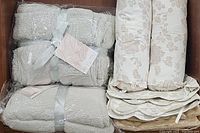 Overview of two packaged blankets, two bolster pillows and folded linens