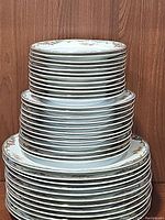 Stack of 36 Noritake Oxford china plates grouped by size with floral and gold trim border.