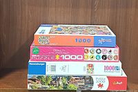 Stacked view of four assorted puzzle boxes, labels visible, confirming count and brands.