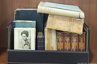 Wide shot of all vintage books showing various sizes and conditions in a black leather case.